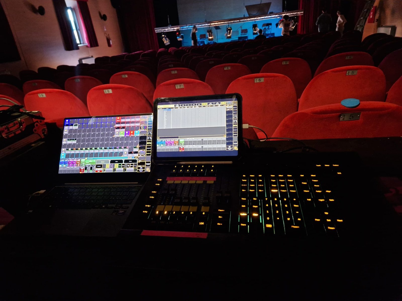 Console e schermi della regia luci davanti alla platea di un teatro